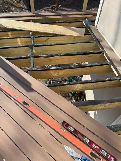 Deck framing with composite boards and a level on the joists