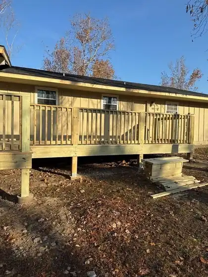 New treated-pine deck and railing on a yellow house