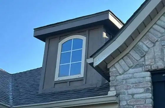 Dormer and new shingles against a blue sky