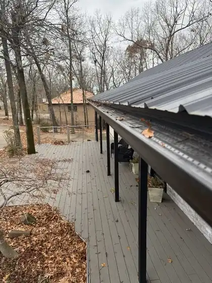 Gutter guard along a metal porch roof