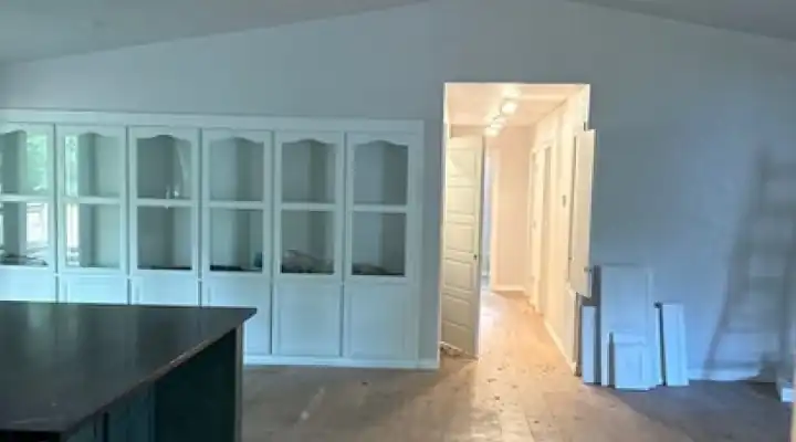 Remodeled room with white built-in cabinets and an island